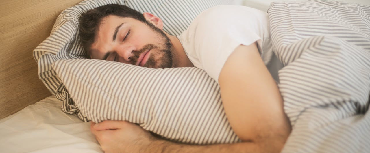 Peaceful man sleeping soundly after taking magnesium glycinate for better sleep and relaxation